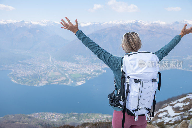 徒步旅行者女性站在山顶双臂伸出