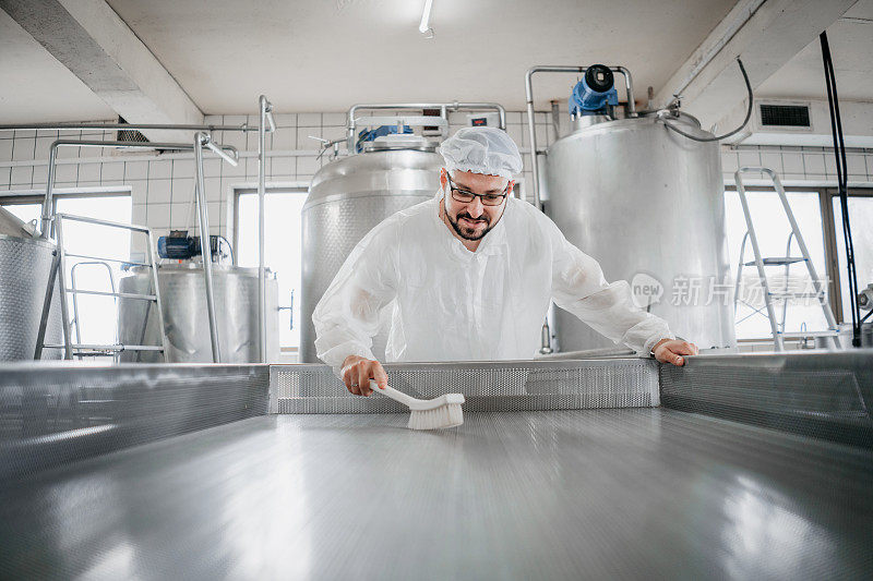 一个工人在牛奶厂清洗机器