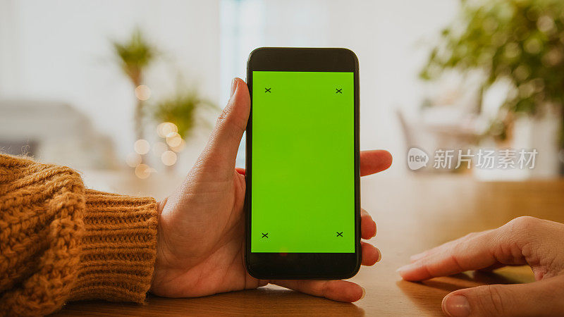 女性手持智能手机与色度键绿色屏幕