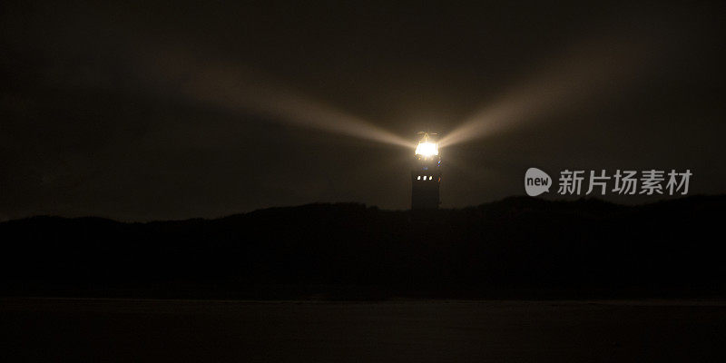 沙丘上的灯塔在夜间发光