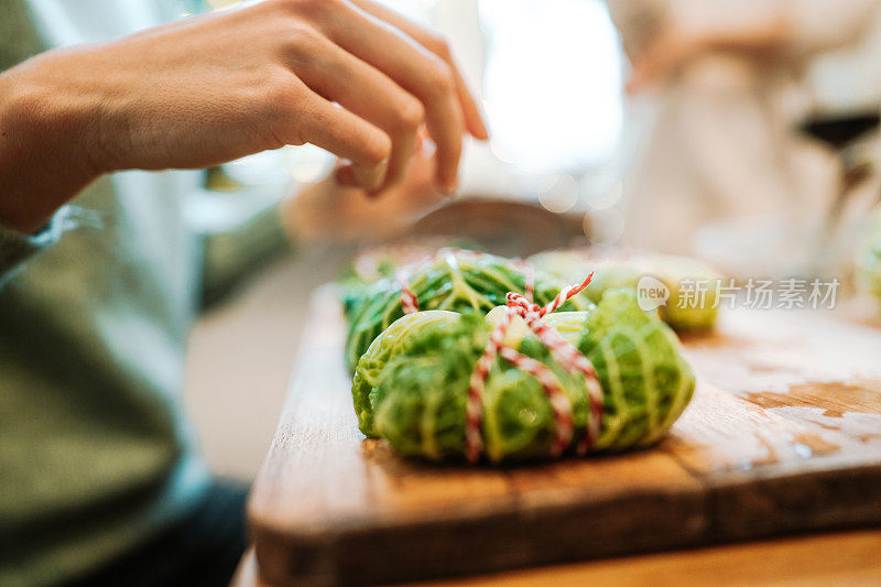 妇女们的手正在做圣诞晚餐的蔬菜卷