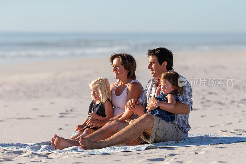 一个年轻的家庭在沙滩上享受一天