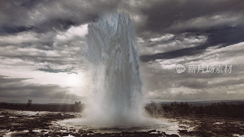 冰岛Strokkur间歇泉喷发戏剧性的日落天空