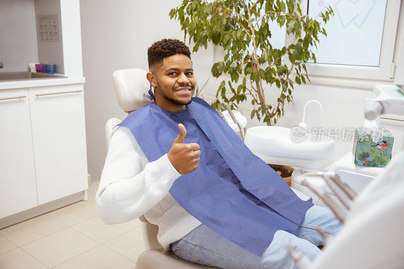 一个年轻的非洲裔美国人在牙医那里摆姿势拍照