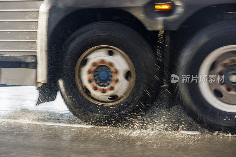 在暴雨中，卡车行驶在被雨水淹没的街道上