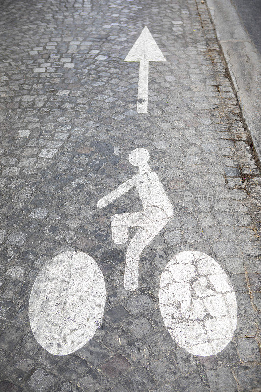 鹅卵石街道上画着自行车道的标志