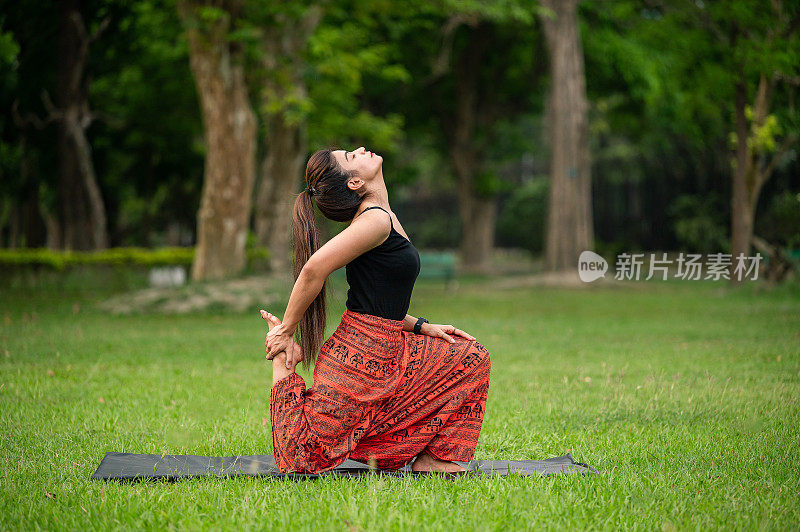 年轻女子在公园户外做瑜伽体式