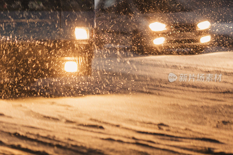 夜晚街道上的汽车。暴雪。飘落的雪在黑暗的背景。雪花。冬天的天气。气候。风暴。灯笼在黑暗中发光。光线