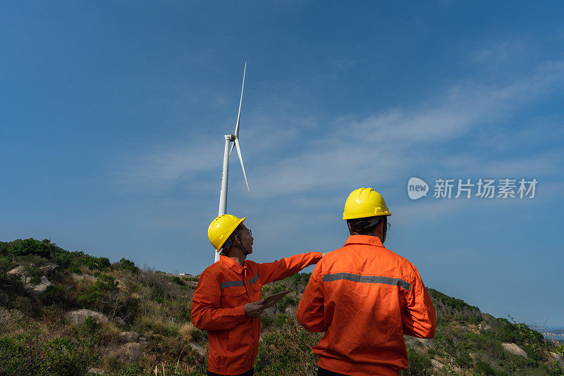 电力工程师使用平板记录风电场运行情况