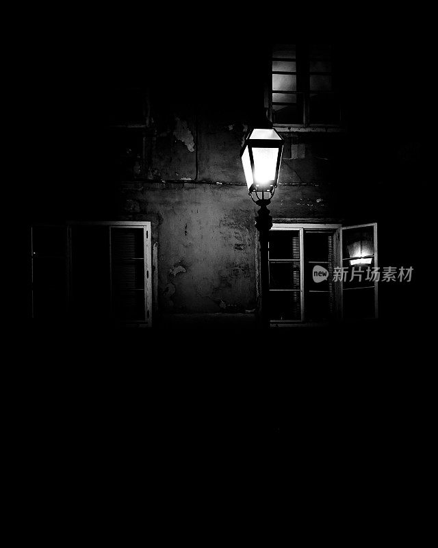 街灯在窗户的映衬下在黑暗中发光。