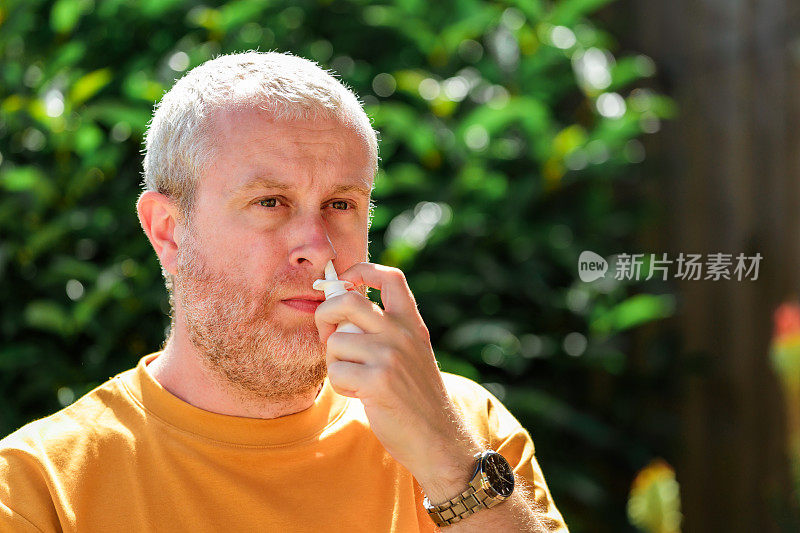 患有花粉热过敏的男子正在使用鼻腔喷雾剂