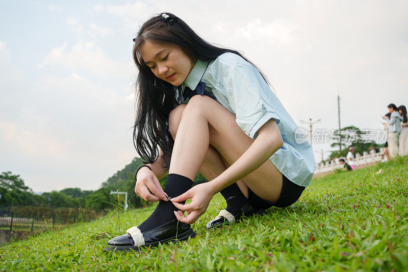 女人在草地上检查鞋带