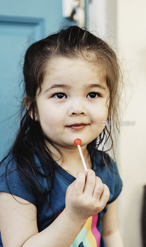 可爱的亚洲混血小女孩和棒棒糖的肖像