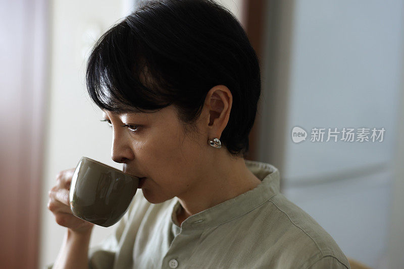 成熟的女人在家喝一杯咖啡