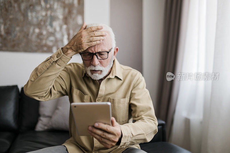 愤怒的老人祖父使用数字平板电脑，搜索网页，加载feed，社交媒体。和孩子们，孙子们交流