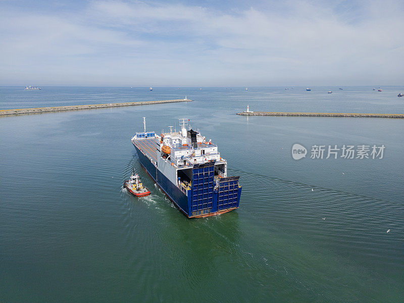 拖船随船驶离货港。国际港口的货船鸟瞰图和国际海运。