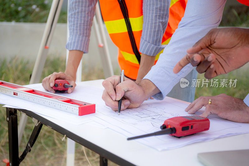 团队年轻工程师与同事一起在施工现场进行规划，检查和调查，建筑师讨论和查看蓝图，工业和房地产工人概念。