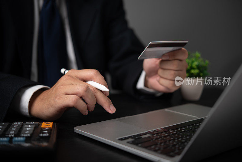 网上支付金融和银行概念。使用信用卡和笔记本电脑进行网上购物的商人。