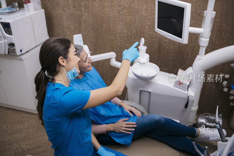 女牙医在诊所向病人展示数码x光片