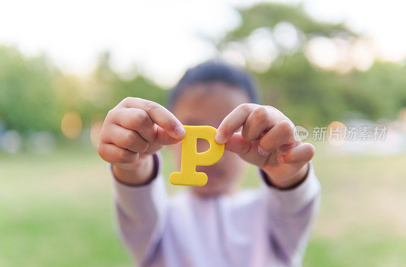 小孩拿着字母“P”