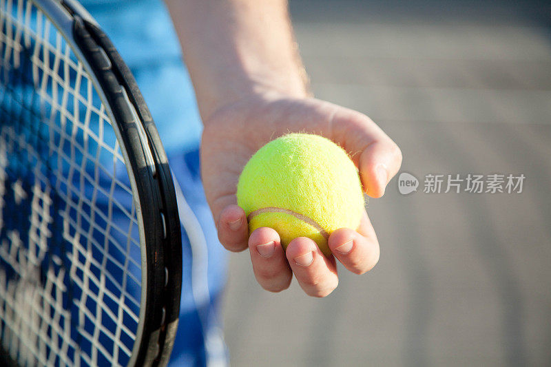 一个运动员正在室外的球场上打网球。男手握网球拍，出黄球。男人有锻炼。夏天的体育活动。