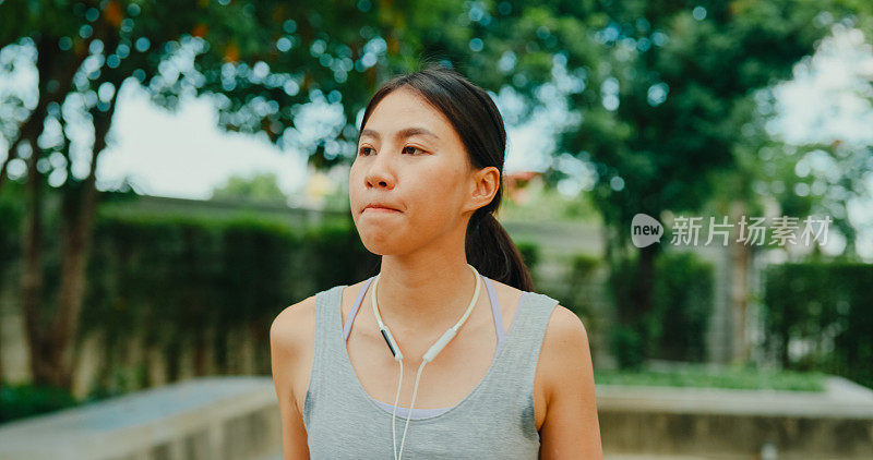 年轻的亚洲女运动员跑步者在城市公园运动后喝蛋白质奶昔。饮食和健康食品锻炼身体。