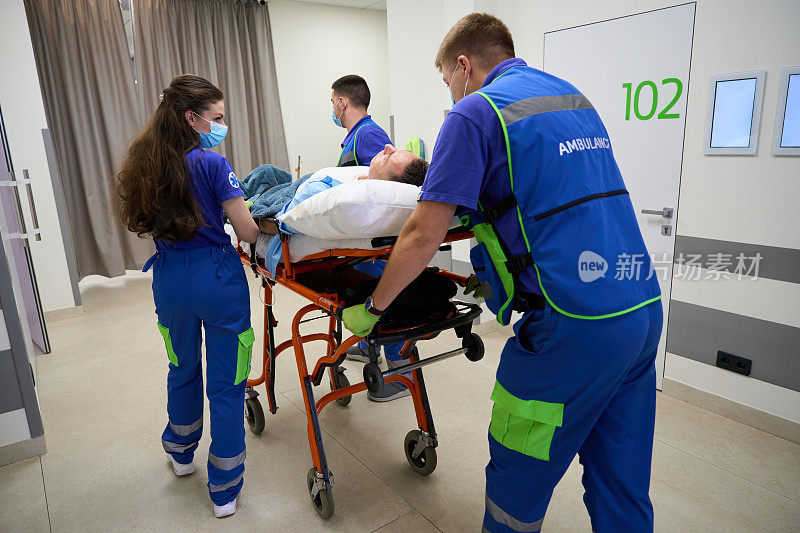 医护人员推着轮床，在医院走廊上抬着病人