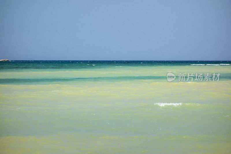 沙滩上蓝绿色海水的柔和波浪。没有人。