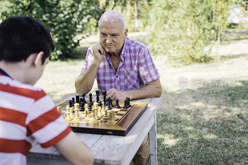 爷爷和孙子在一起下棋。