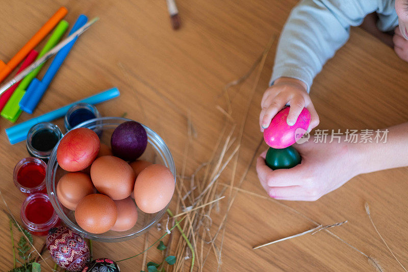 孩子们的手敲打着五颜六色的复活节彩蛋