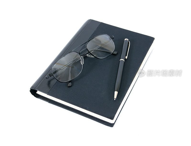钢笔、书和眼镜孤立在白色的背景上