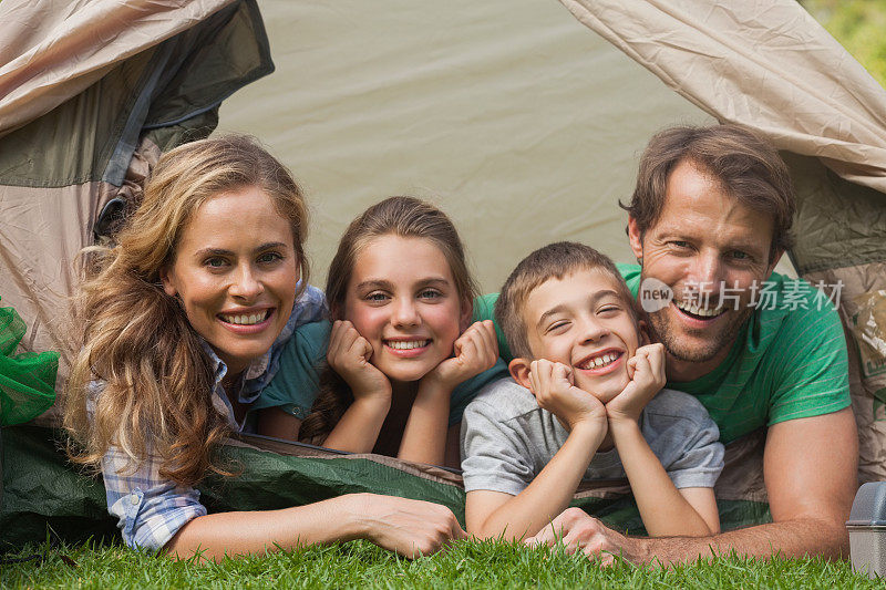 幸福的一家人躺在帐篷里微笑