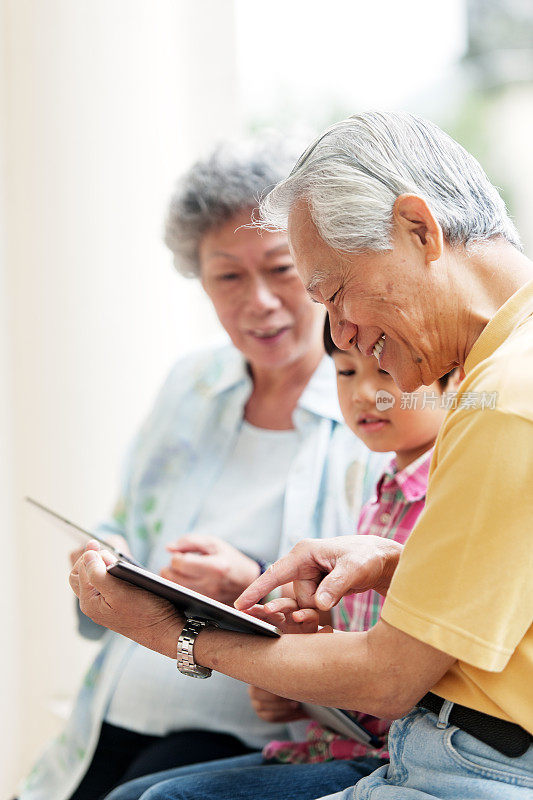 孙子教祖父母如何使用数字平板电脑