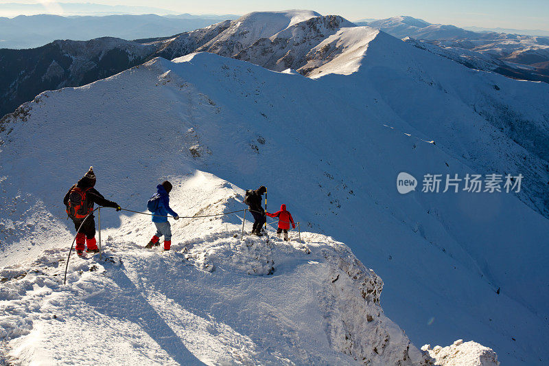 一群游客在冬天下陡坡
