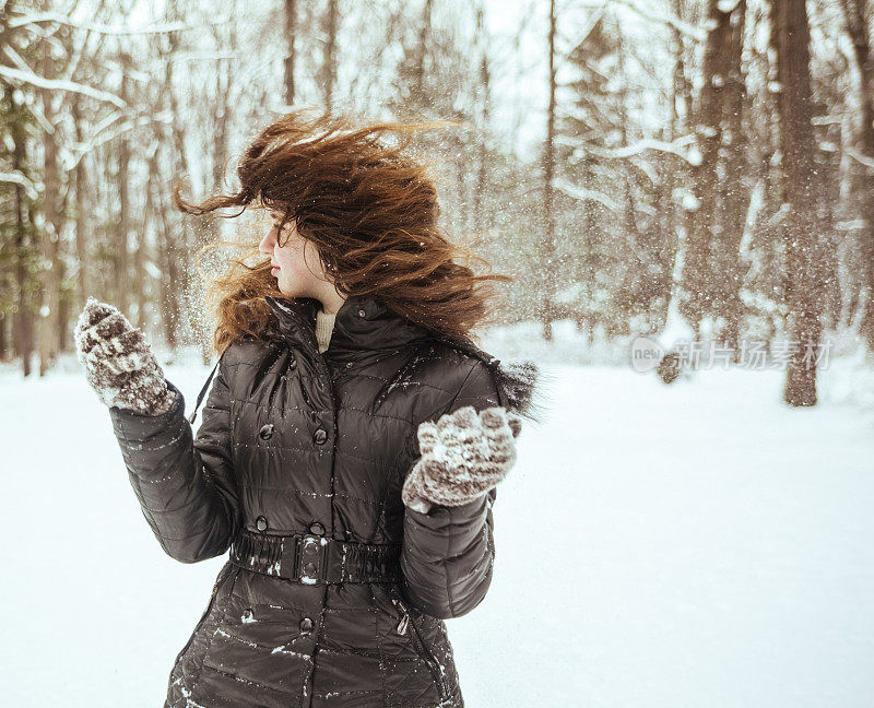 十几岁的长发女孩玩雪