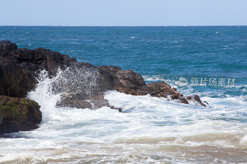 海浪拍打着夏威夷海滩上的岩石