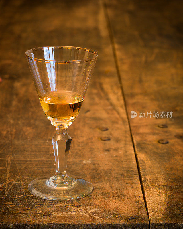 利口酒——旧木桌上的古董玻璃杯。