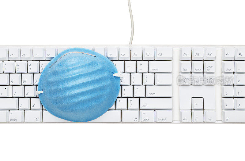 白色电脑键盘上的蓝色医用口罩