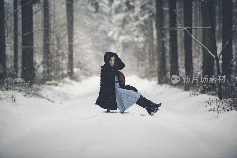 年轻女子红色复古椅子雪地森林