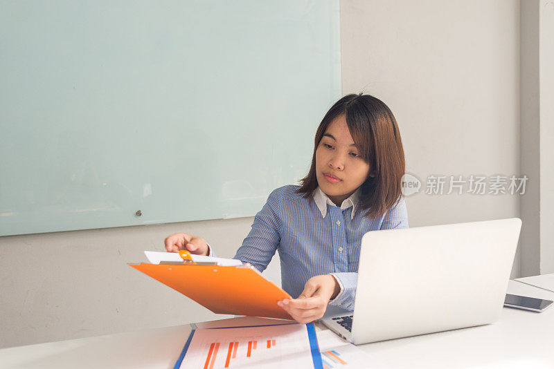 亚洲办公室女职员检查销售报告的信息