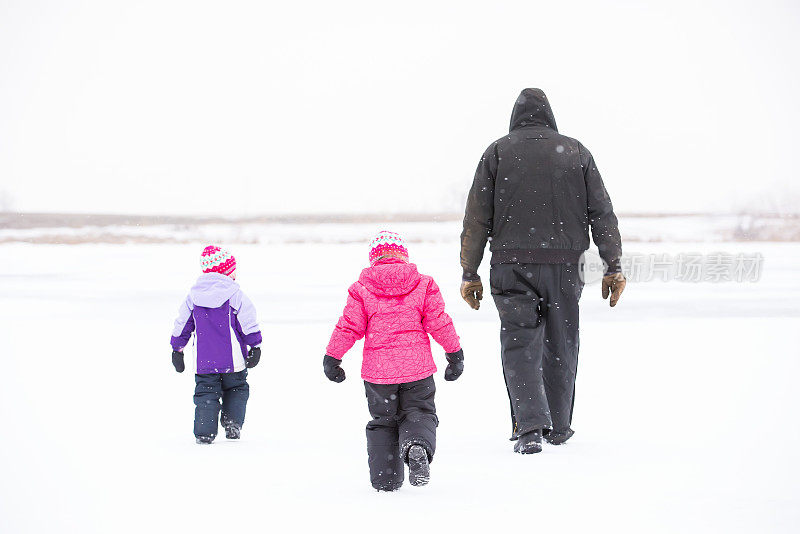 两个小女孩和爷爷在冬天的雪