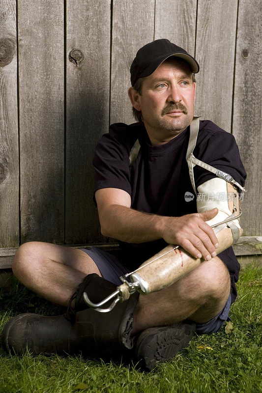 一个戴假肢的人坐在草地上。