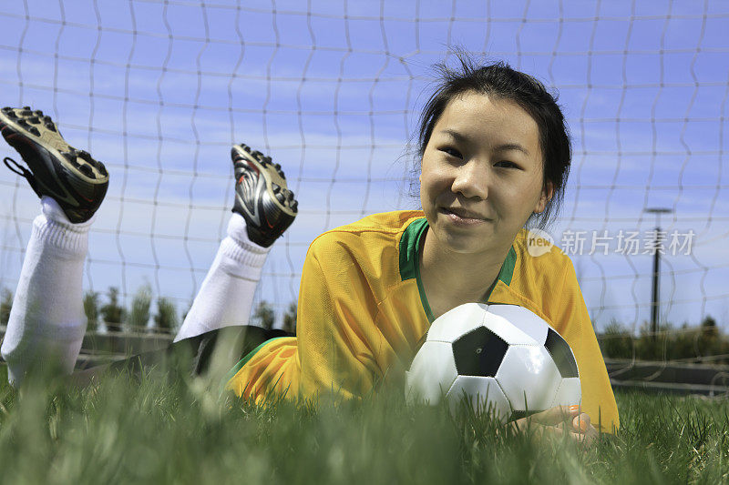 年轻女孩足球-水平草肖像