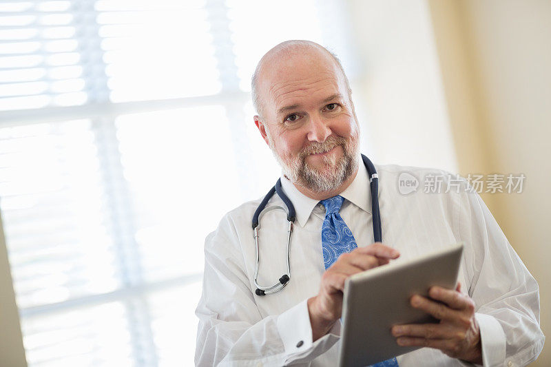 男性医生在临床中使用数字平板电脑