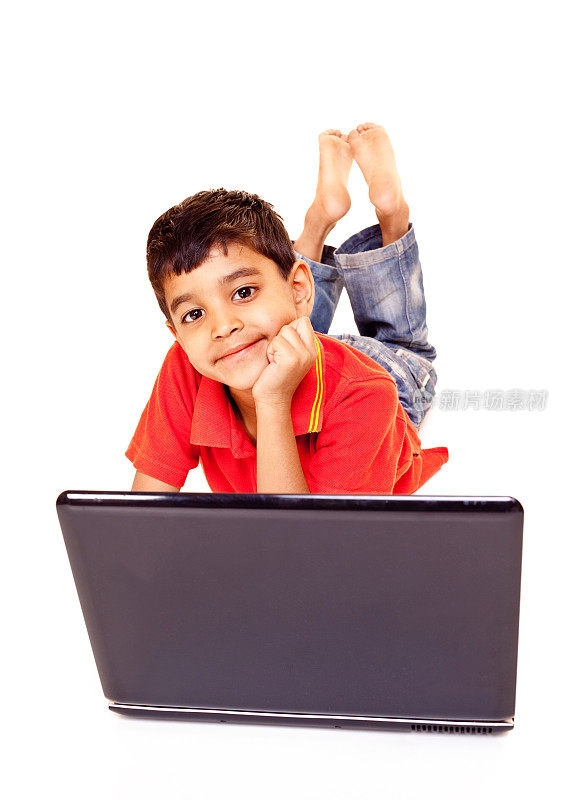 愉快的小印度男孩使用笔记本电脑孤立的白色