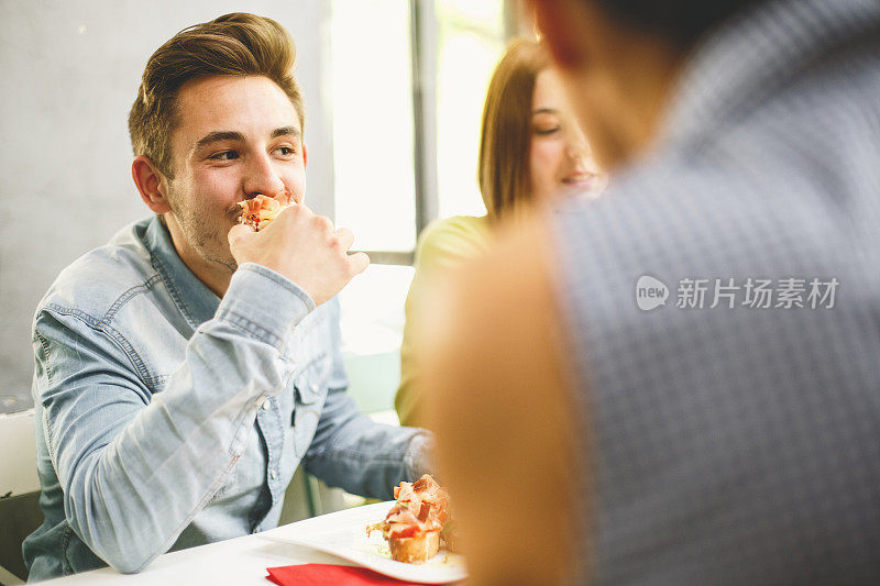 一个年轻人正在和他的朋友吃饭