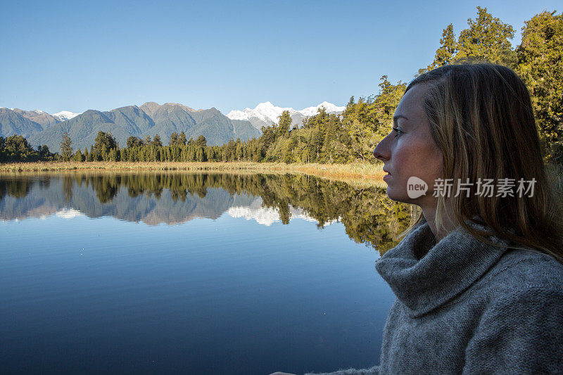 年轻女子看壮观的山湖景观