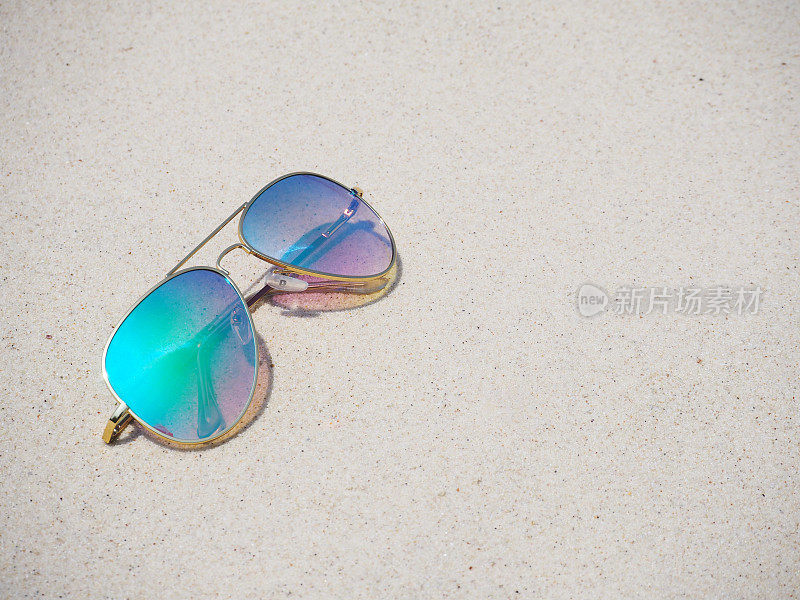 时尚的镜子太阳镜在沙滩的背景