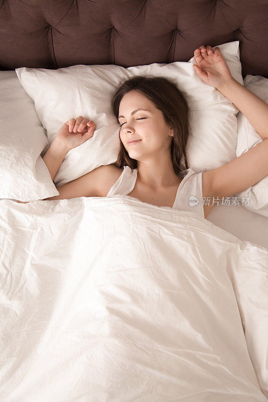 放松的女人躺在床上闭着眼睛