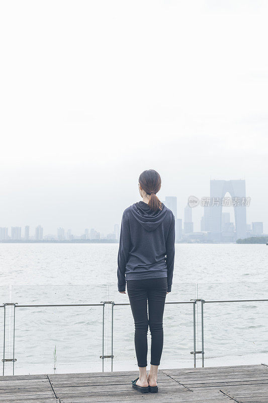 后视图的女人站在湖边看美丽的风景